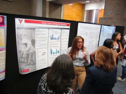 Claudia Rugama explains to first year Rutgers students about her summer research
